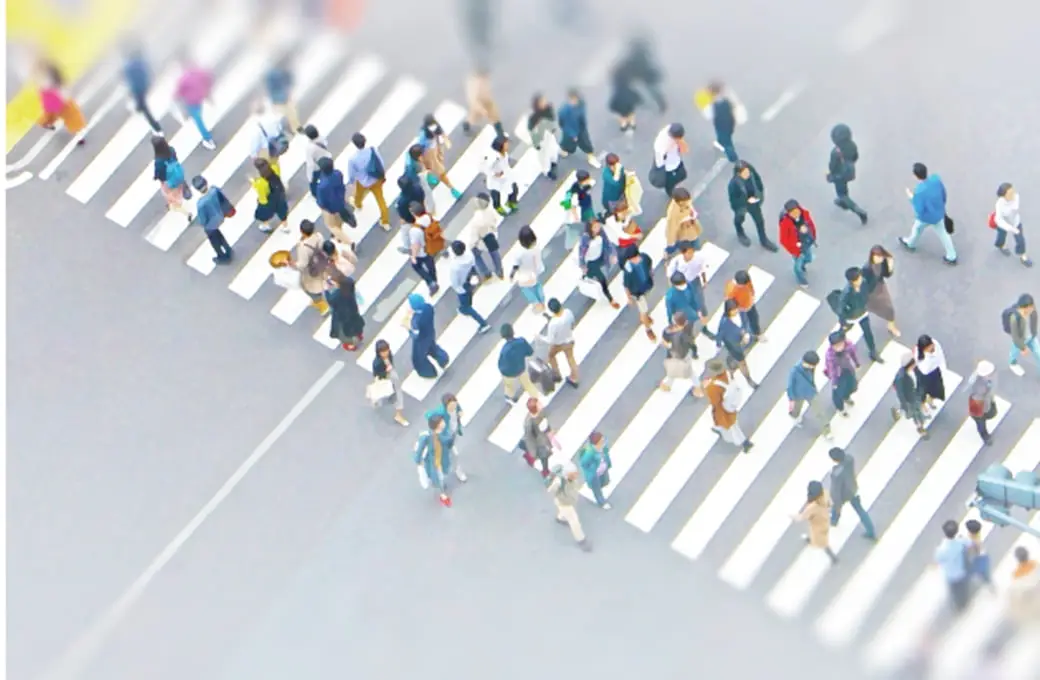 横断歩道を渡る大勢の人々を上から撮影した様子。