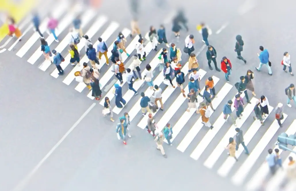 横断歩道を渡る大勢の人々を上から撮影した様子。